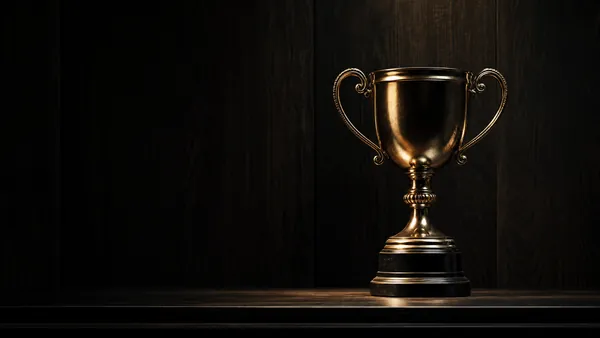 Troféu iluminado em prateleira escura sob holofote