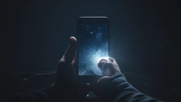 Tela de celular brilhando em ambiente escuro, imagem conceitual