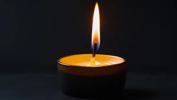 Chama de vela em quarto escuro, imagem íntima e cinematográfica